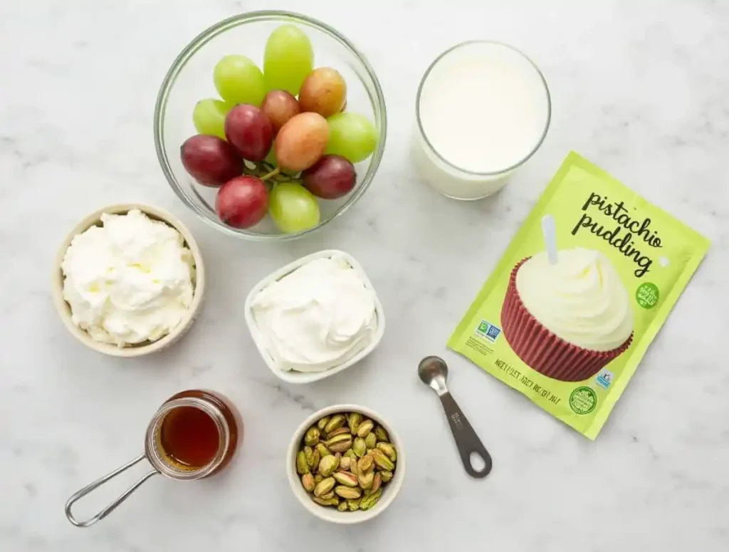 Essential ingredients for making a Pistachio Pudding Recipe with Grapes, displayed on a kitchen counter.