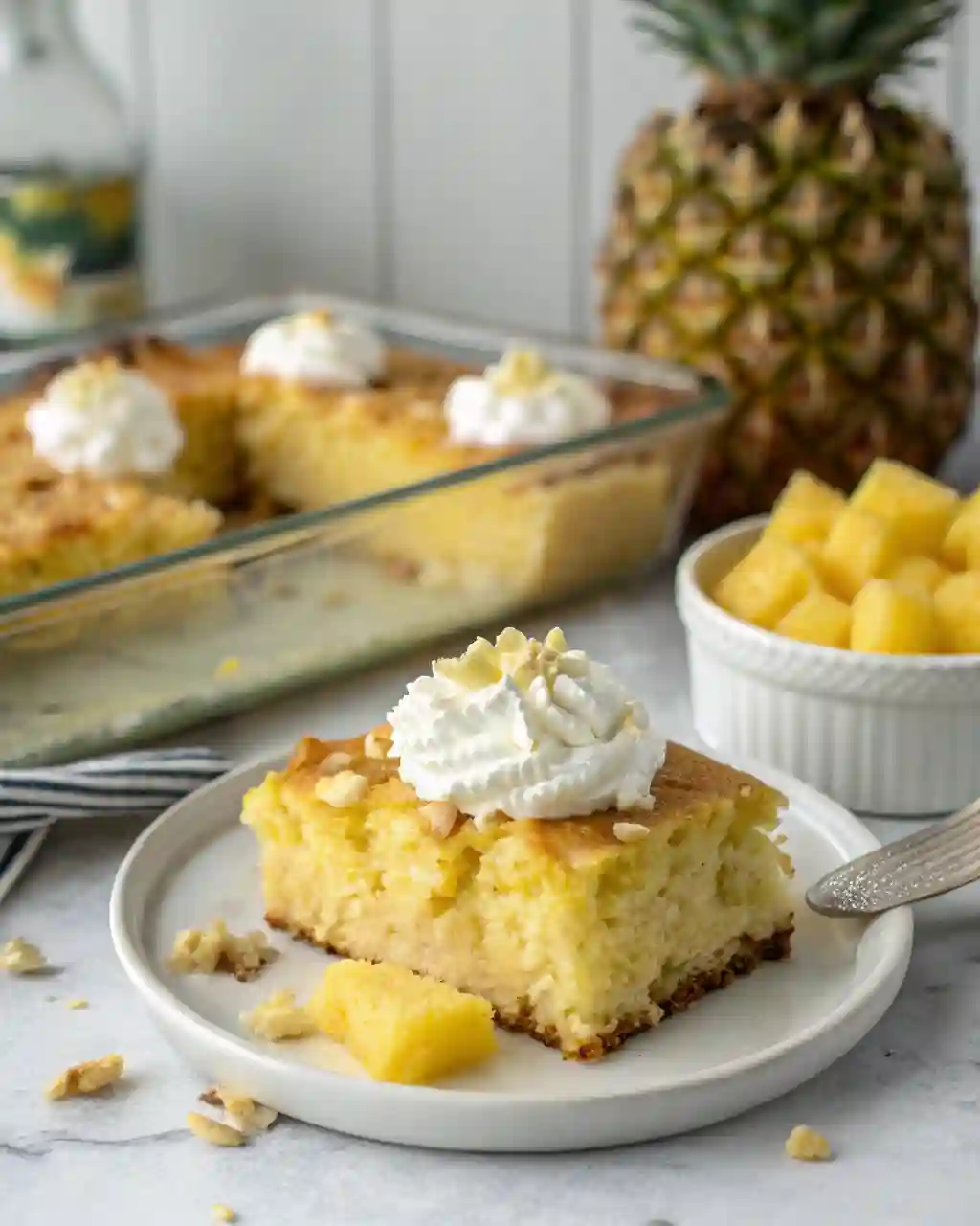 Moist pineapple condensed milk cake with creamy topping in a glass baking dish